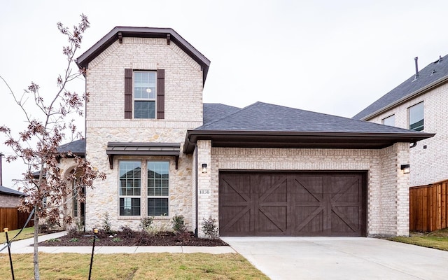 view of front of house featuring roof with shingles, brick siding, an attached garage, fence, and driveway