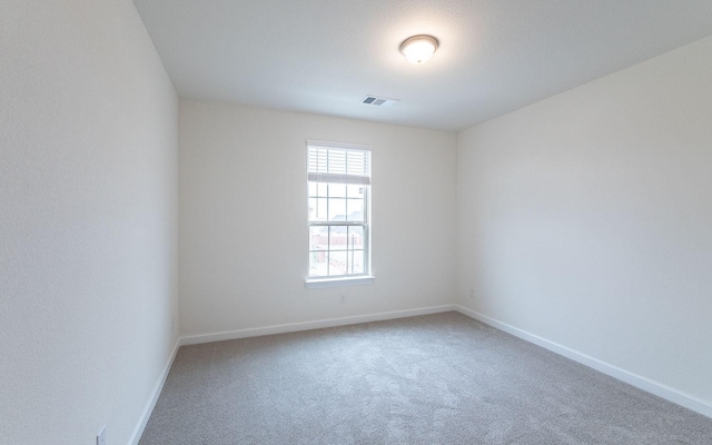 carpeted empty room with visible vents and baseboards