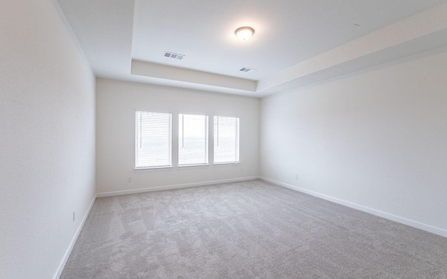 carpeted empty room featuring visible vents and baseboards