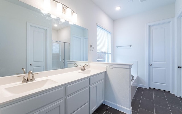 full bath with a stall shower, double vanity, a sink, and tile patterned floors