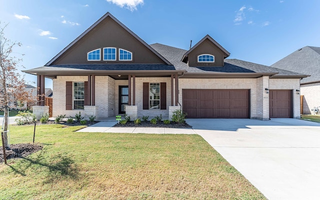 view of front of house with a garage, a front lawn, and covered porch