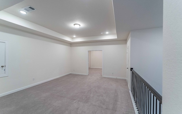 interior space featuring carpet and a raised ceiling