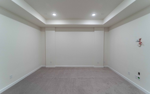 spare room featuring a tray ceiling and carpet