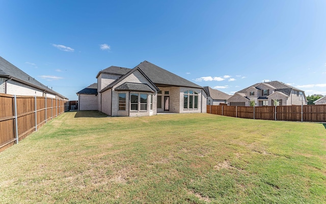 rear view of property featuring a lawn