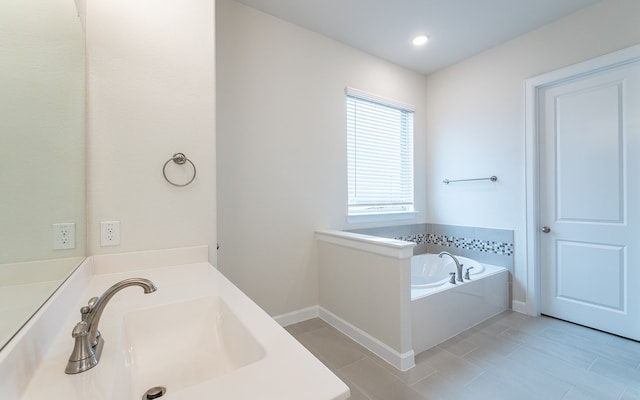 bathroom with tile flooring, sink, and a bathing tub