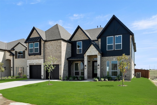 view of front of home with a garage, central air condition unit, and a front yard