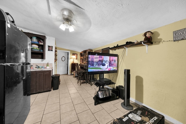 living room with sink, light tile flooring, ceiling fan, and vaulted ceiling