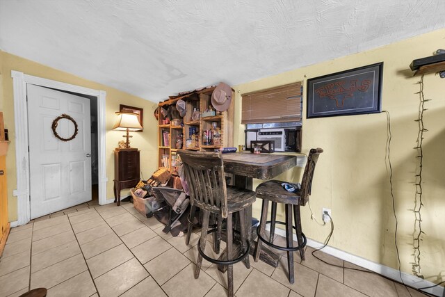 tiled dining area with a textured ceiling