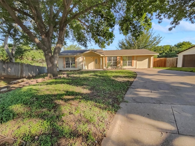 single story home with a garage and a front lawn