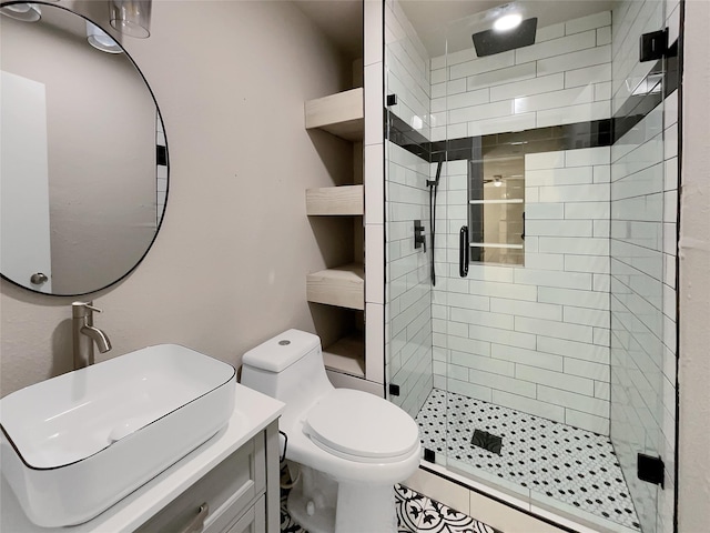 bathroom featuring a shower with shower door, toilet, vanity, and tile patterned flooring