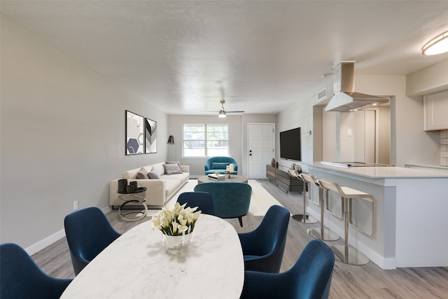 dining space featuring ceiling fan and light wood-type flooring