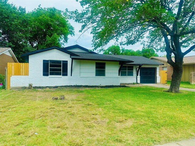 single story home featuring a front lawn and a garage