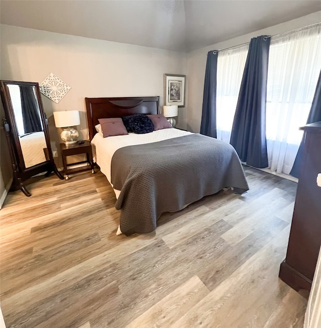 bedroom featuring vaulted ceiling and wood-type flooring