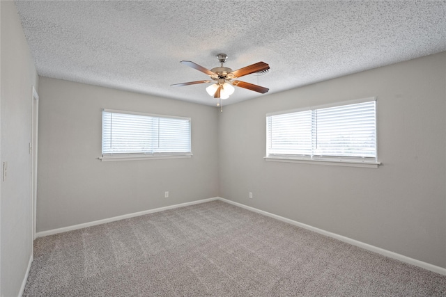 spare room with a textured ceiling, carpet floors, and ceiling fan