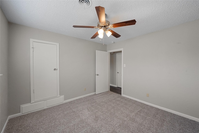 carpeted spare room with ceiling fan and a textured ceiling