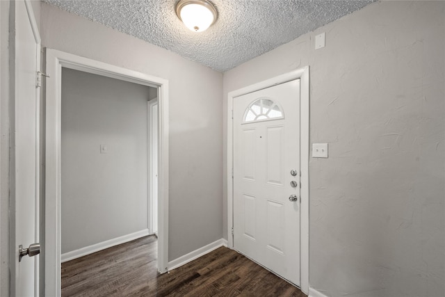 entrance foyer featuring a textured ceiling and dark wood-type flooring