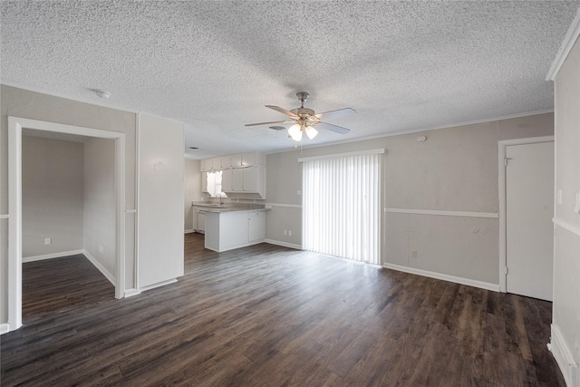 unfurnished living room with ceiling fan, dark wood-type flooring, and a textured ceiling