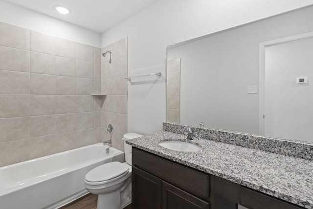 full bathroom with toilet, tiled shower / bath combo, hardwood / wood-style flooring, and vanity