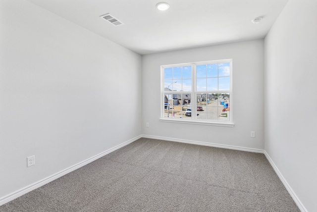 carpeted empty room with visible vents and baseboards