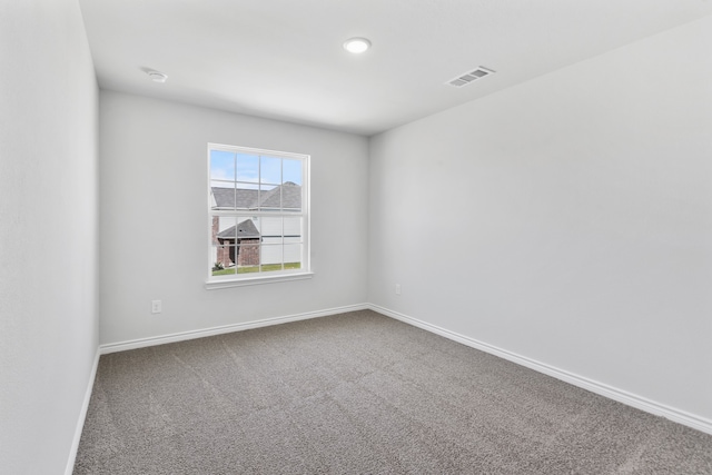 empty room featuring carpet, visible vents, and baseboards