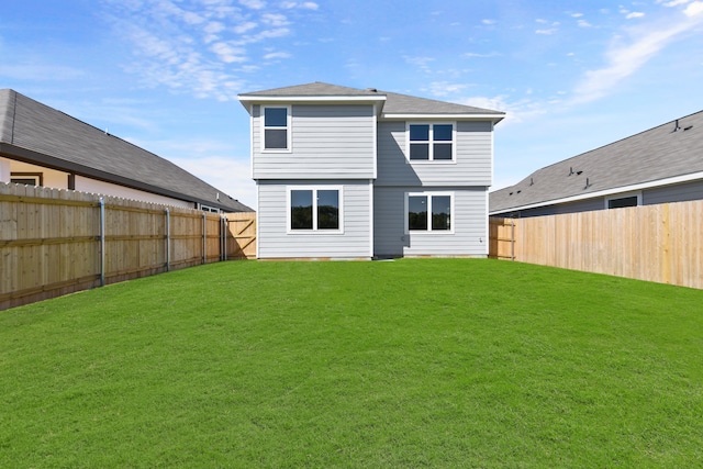 back of house featuring a fenced backyard and a yard