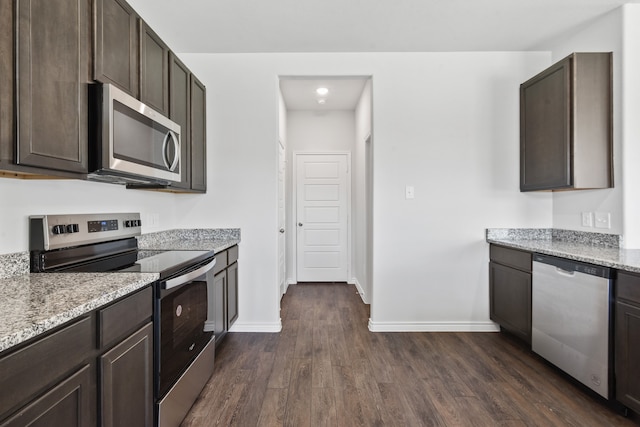 kitchen featuring dark hardwood / wood-style floors, dark brown cabinetry, stainless steel appliances, and light stone countertops