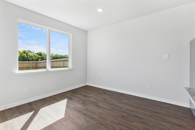 empty room with dark wood-style floors, baseboards, and recessed lighting