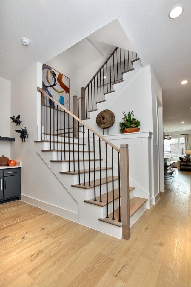 stairs featuring recessed lighting, wood finished floors, and baseboards