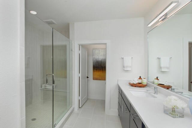 bathroom with visible vents, baseboards, tile patterned floors, vanity, and a shower stall