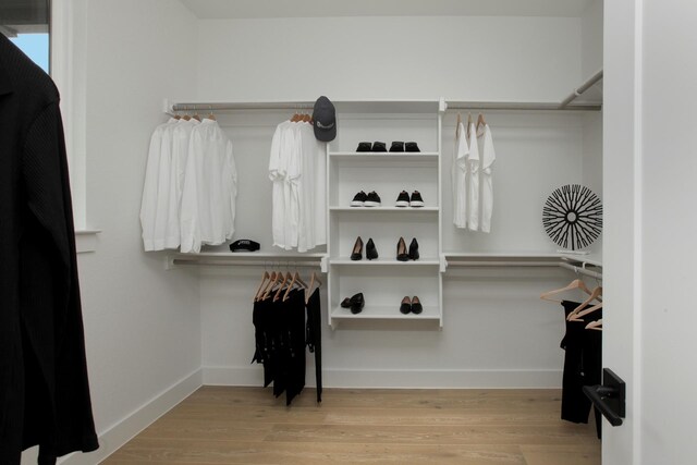 walk in closet with wood finished floors