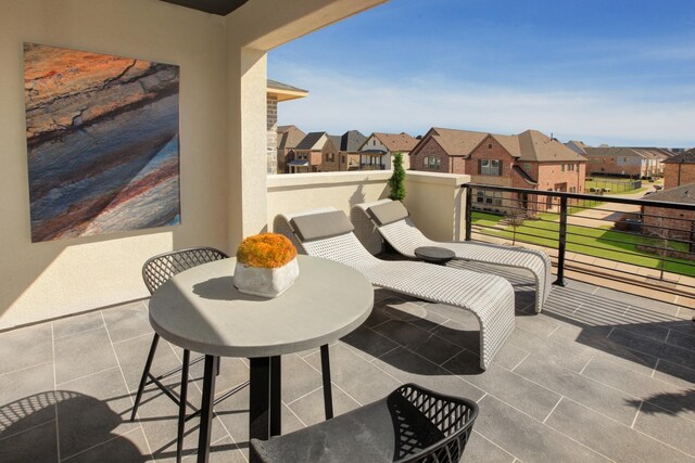 view of patio featuring a balcony and a residential view