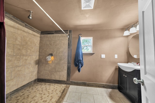 bathroom featuring tile flooring, walk in shower, and vanity