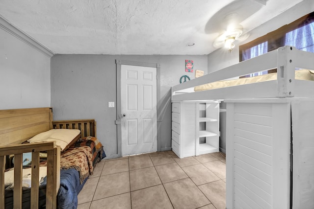 bedroom with a textured ceiling and light tile floors