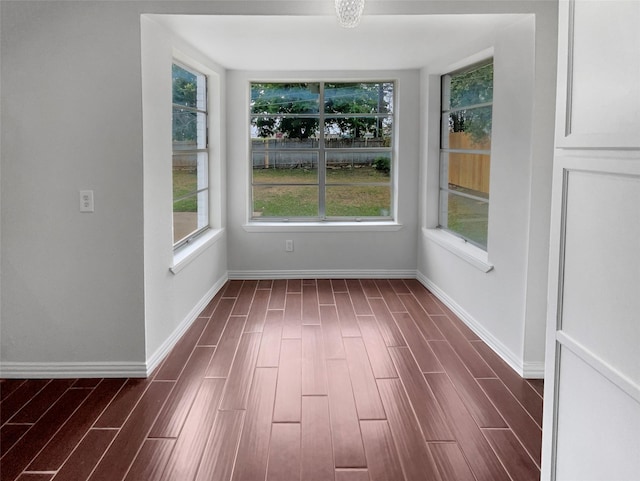 unfurnished dining area with dark wood-type flooring