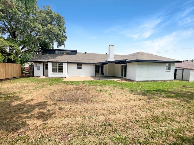 rear view of house featuring a patio area and a lawn