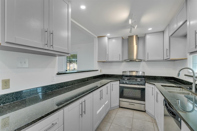 kitchen featuring stainless steel appliances, wall chimney range hood, sink, and a healthy amount of sunlight