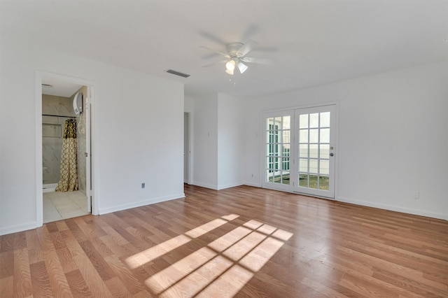 empty room with ceiling fan and light hardwood / wood-style flooring