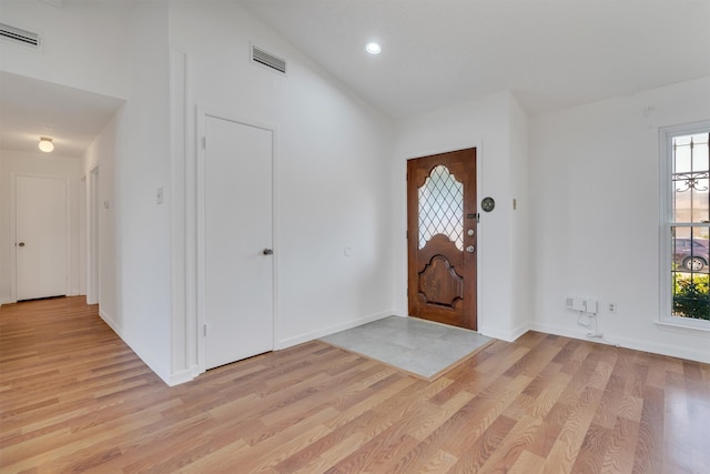 foyer featuring light hardwood / wood-style floors, lofted ceiling, and a healthy amount of sunlight