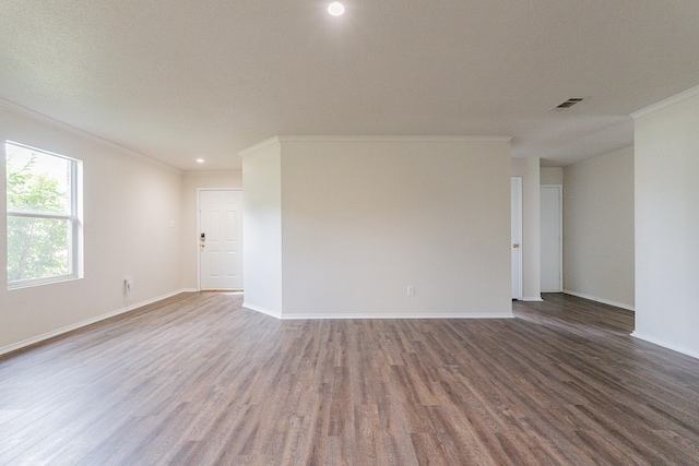 spare room featuring ornamental molding and dark wood-type flooring