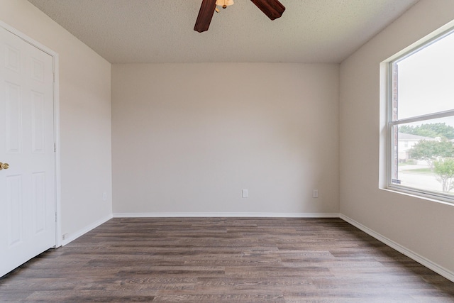 spare room featuring plenty of natural light, dark hardwood / wood-style flooring, and a textured ceiling