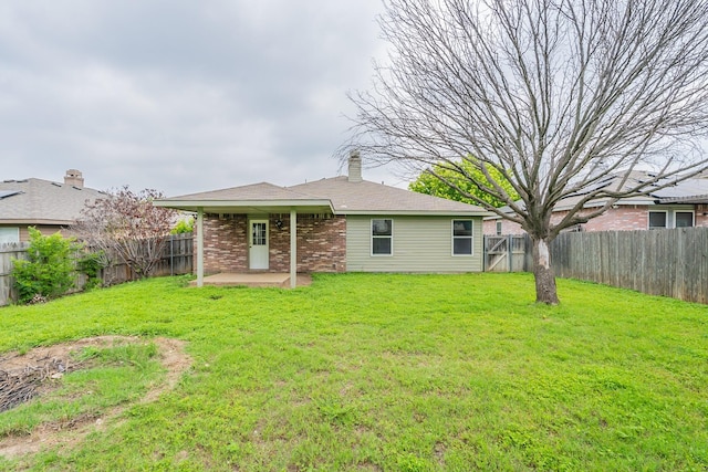 rear view of house with a lawn and a patio