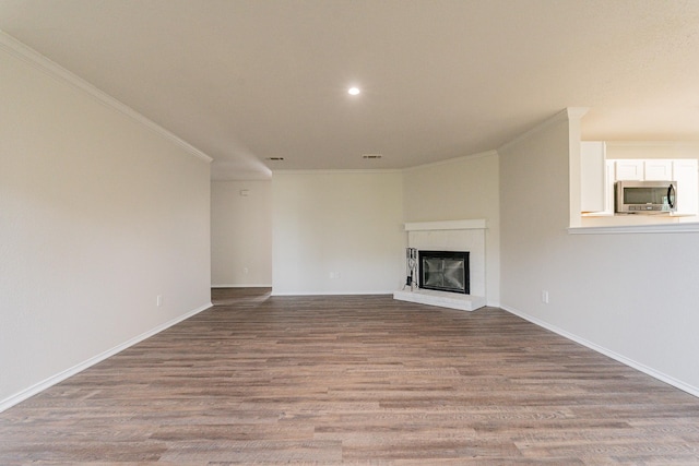 unfurnished living room with light hardwood / wood-style floors, crown molding, and a fireplace