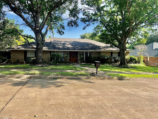 ranch-style home featuring brick siding and a front yard