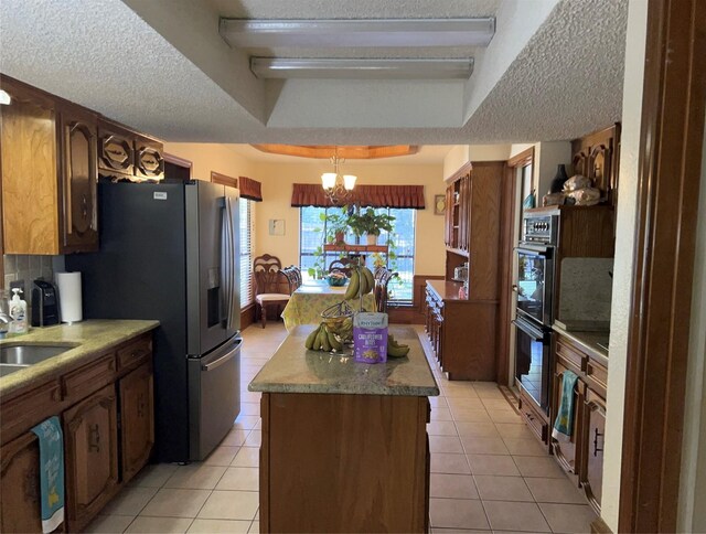 kitchen featuring a notable chandelier, light tile floors, backsplash, and a textured ceiling