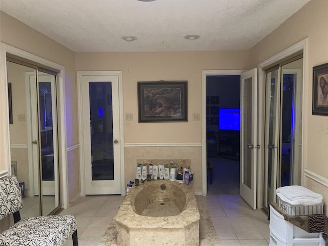 bathroom featuring tile floors, a textured ceiling, and french doors