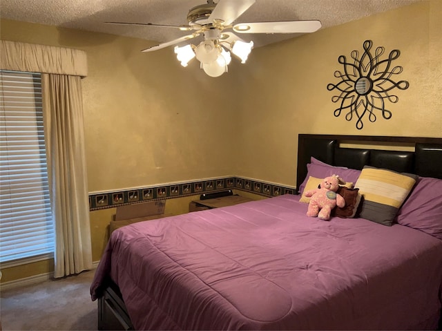 carpeted bedroom with a textured ceiling and ceiling fan