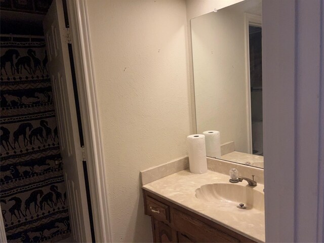 bathroom featuring vanity and a textured wall