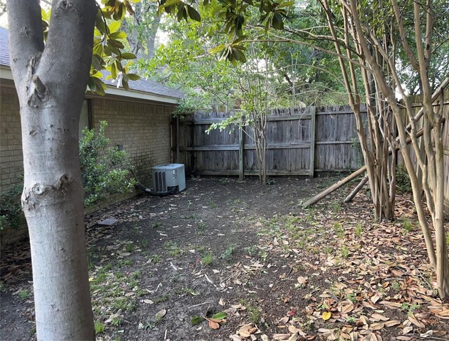 view of yard featuring central air condition unit and fence