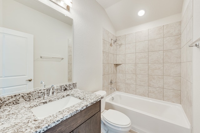 full bathroom with toilet, tiled shower / bath, vanity, and lofted ceiling