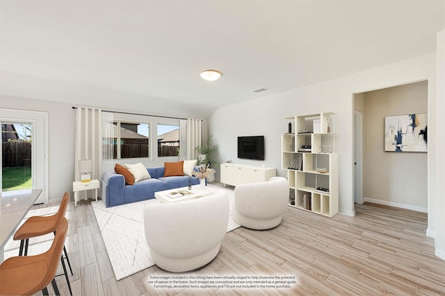 living room with visible vents, baseboards, and wood finished floors